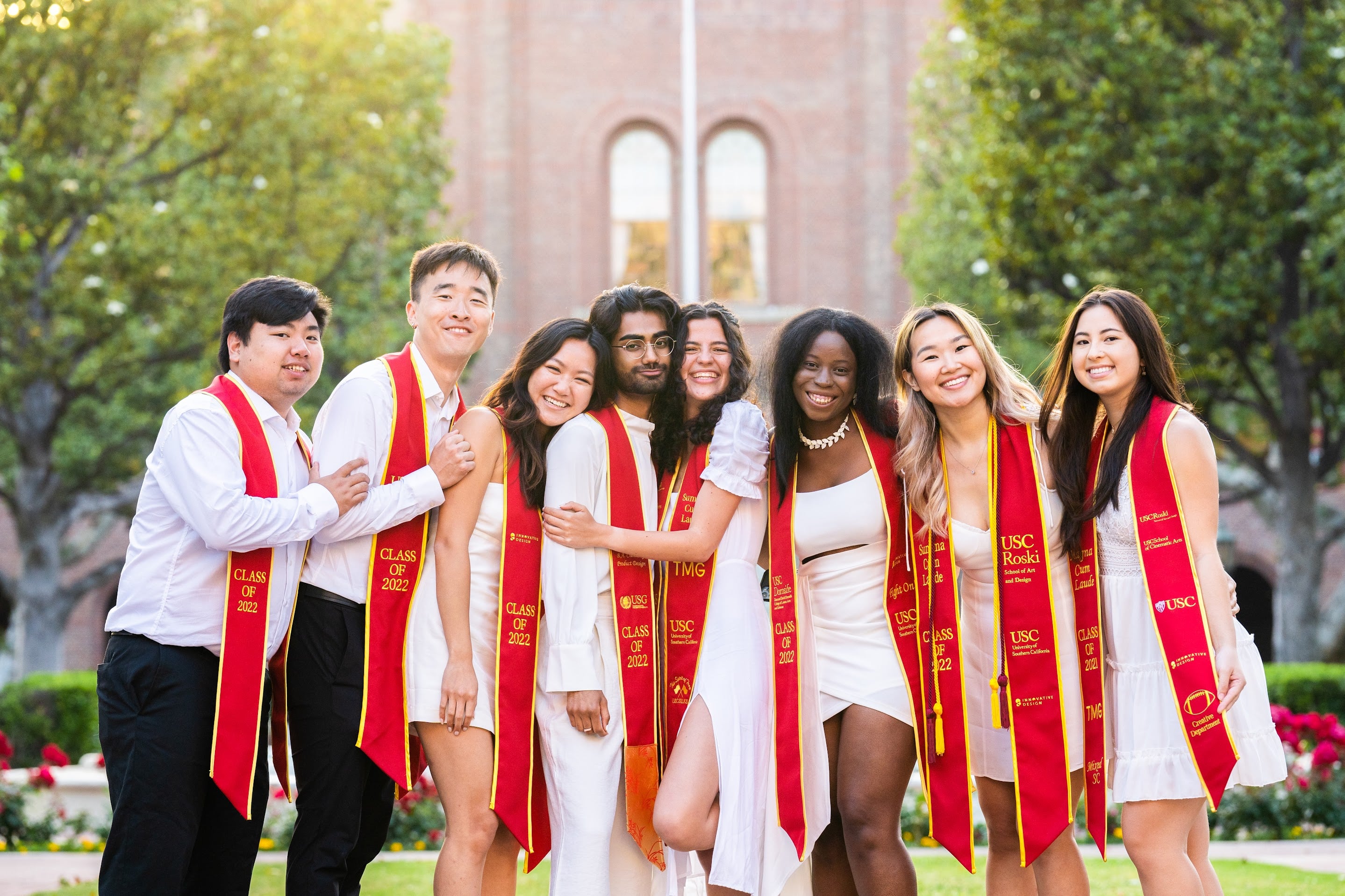 8 smiling newly graduated USC students
